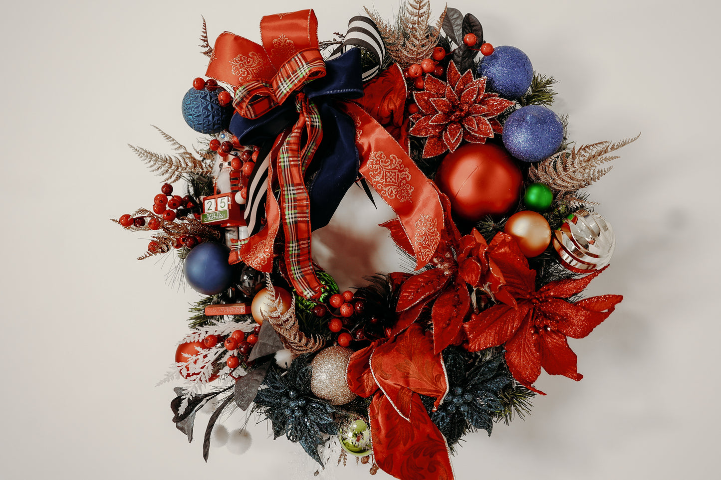 Nutcracker Christmas wreath with vibrant red, blue, and green ornaments.

Handcrafted holiday wreath with poinsettias, berries, and luxury ribbon.

Festive front-door wreath featuring Nutcracker and plaid accents.

Red and blue Christmas wreath designed by Duvall Designs.

Elegant Nutcracker wreath with traditional holiday colors.

Vibrant Christmas door décor with ornaments and lush greenery.

Whimsical handcrafted wreath featuring Nutcracker and glitter poinsettias.

Traditiona red and blue holiday wreath