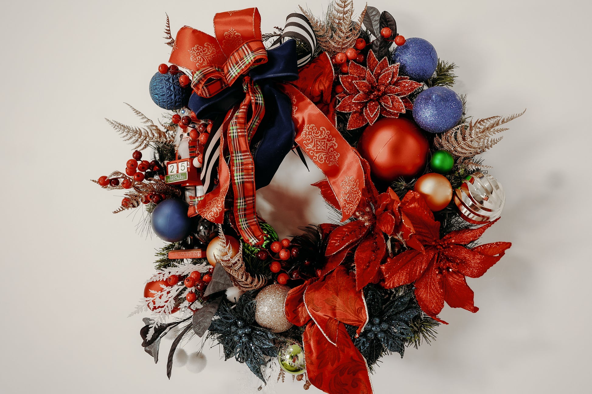 Nutcracker Christmas wreath with vibrant red, blue, and green ornaments.

Handcrafted holiday wreath with poinsettias, berries, and luxury ribbon.

Festive front-door wreath featuring Nutcracker and plaid accents.

Red and blue Christmas wreath designed by Duvall Designs.

Elegant Nutcracker wreath with traditional holiday colors.

Vibrant Christmas door décor with ornaments and lush greenery.

Whimsical handcrafted wreath featuring Nutcracker and glitter poinsettias.

Traditiona red and blue holiday wreath